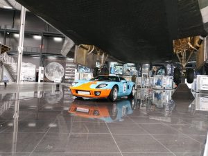 Ein Sportwagen unter der Buran-Raumfähre im Technikmuseum Speyer